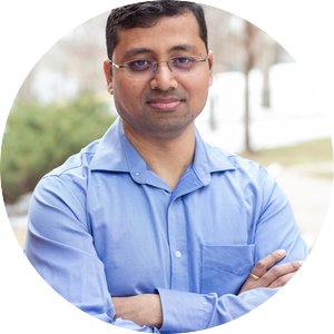 Professional headshot of Anil Meher posed outdoors and wearing a button up