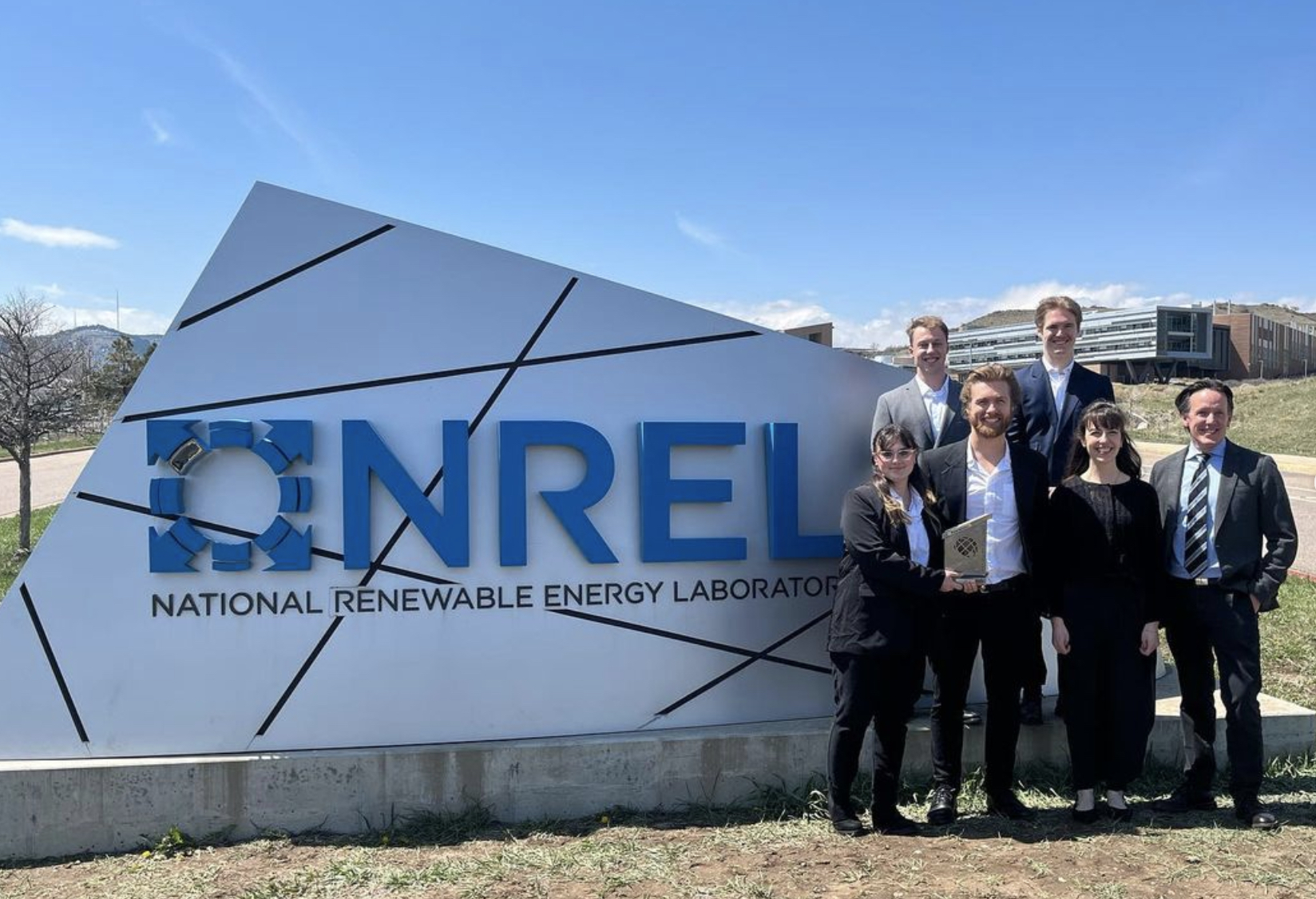 The modular team poses with their award in from of the national renewable energy laboratory sign in Golden, CO.