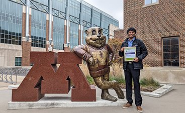 Koushik poses in front of the block M and Goldy Gopher statue on the East Bank campus of the U of M. 