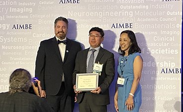 Dr. Wang accepts his award on stage during his induction into the AIMBE College of Fellows