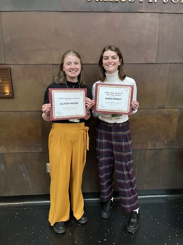 Alli Graper, left, and Sarah Kinney, right, hold up their certificate awards recongizing their achievement.