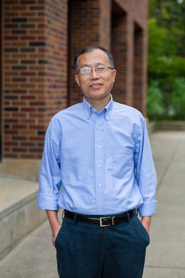 A headshot of Department Head Hua Zhao from the waist up, smiling, and wearing a business casual top. 