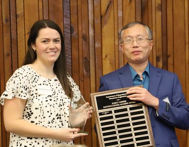 Sarah Whiteside (left) accepts the early career alumni award from Hua Zhao (right).
