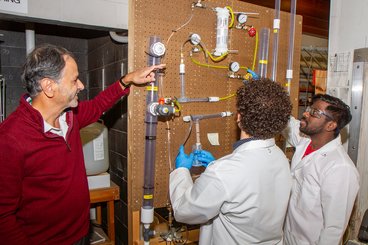 Shri works with undergraduate student Cameron Borner and visiting scholar Gnanaselvan on the jet fuel project. 